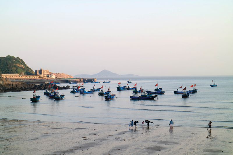 Boats moored off the beach of Shengsi&#x27;s base island are a picturesque backdrop for photo-takers, occasionally taking visitors on fishing trips