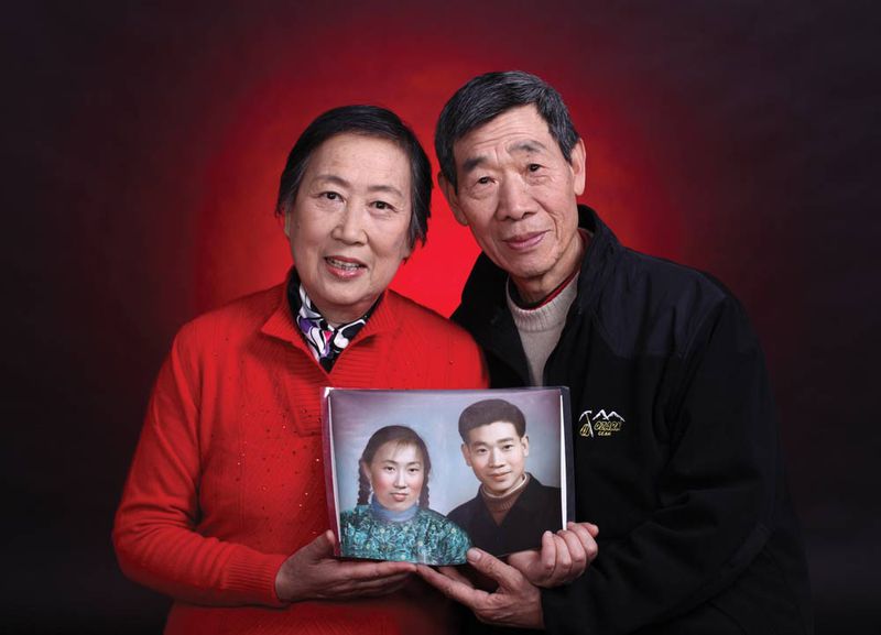 A couple&#x27;s golden wedding anniversary photo taken at China Photo Studio in which they hold their original photo taken at the same studio