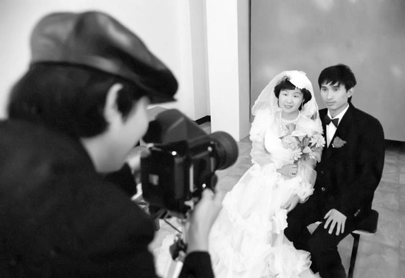 A CPS photographer takes a wedding photo for a young couple in the 1990s