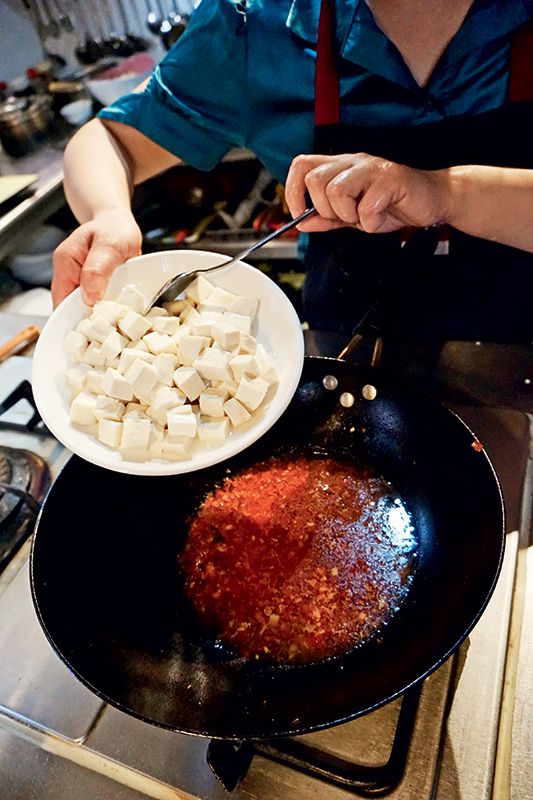 Drain the tofu cubes andpour them into the wokwhen the mapo sauce isboiling. Stir fry gently so thatthe tofu cubes don’t breakapart. Add salt and whitesugar to taste. Boil for aboutfive minutes, and make sureto cover everything in theseasoned sauce.