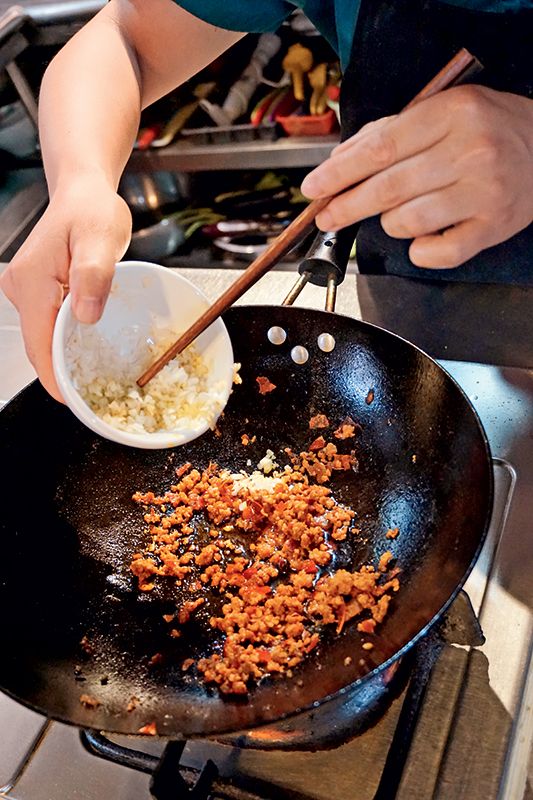 Pour out the water and placethe wok over a high heat.Add cooking oil. When theoil is heated, fry Sichuanpeppercorns for 10 secondsand then remove them. Addthe chopped leek, ginger,garlic, and the minced meat.Stir-fry them together ona high heat until the meatbecomes brown. Add thebean paste and soy sauce,stir-fry for another minute,add water as needed, andyou now have your maposauce.