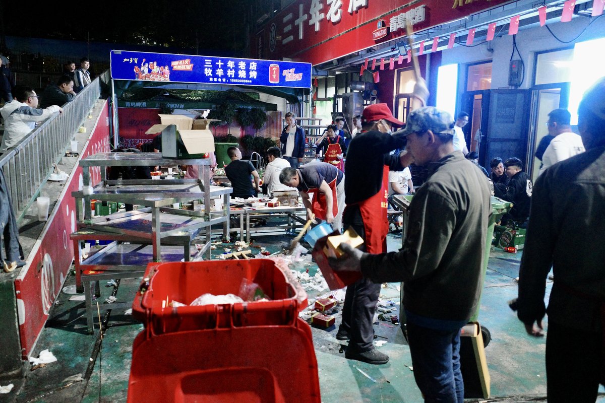 Cleaners sweeping away trash at a barbecue restaurant