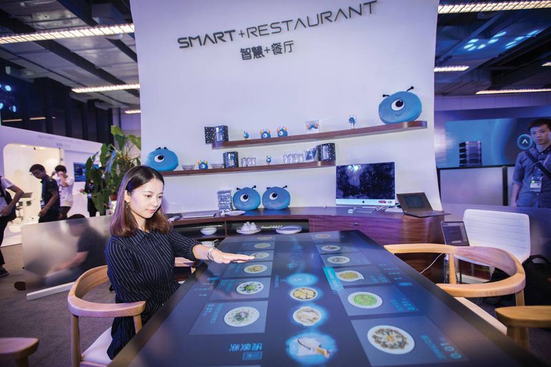 A visitor browses the menu of Alibaba&#x27;s "Smart+Restaurant" system, in an exhibition in Hangzhou in October 2017