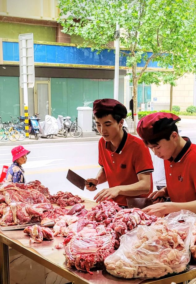 Restaurant staff in Lanzhou, Gansu province, chopping lamb for barbecue skewers