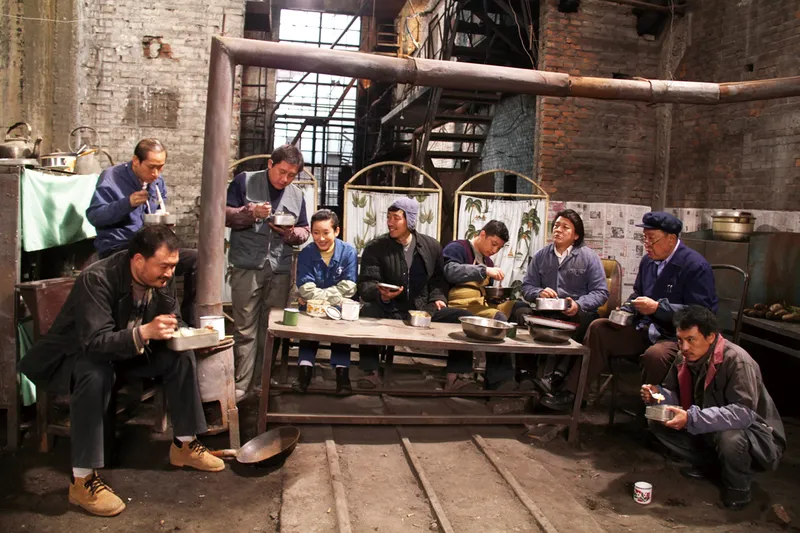 The Piano in a Factory tells the story on how Chen Guilin (center), a laid-off steel worker, tries to make a piano with his former coworkers for his music-loving daughter