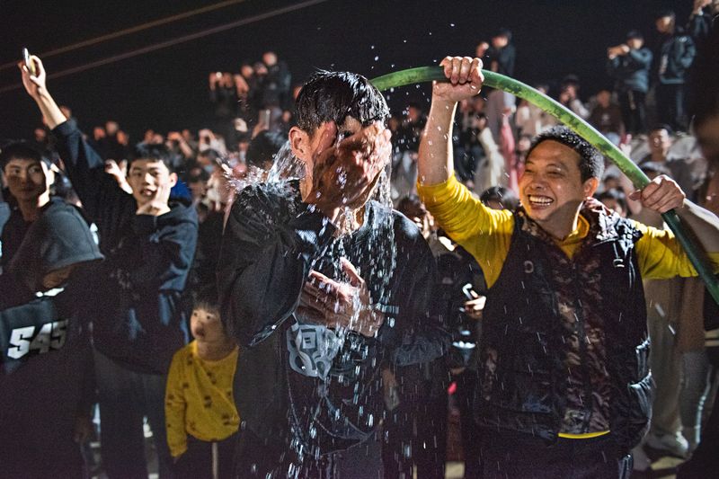 Participants soak themselves in water before charging into the fire