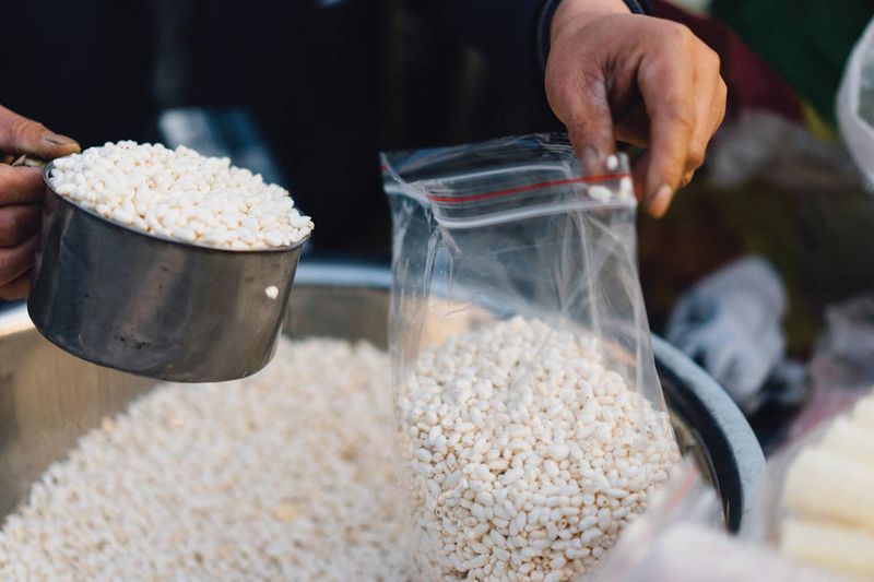 The vendor fills a bag with fresh popped rice