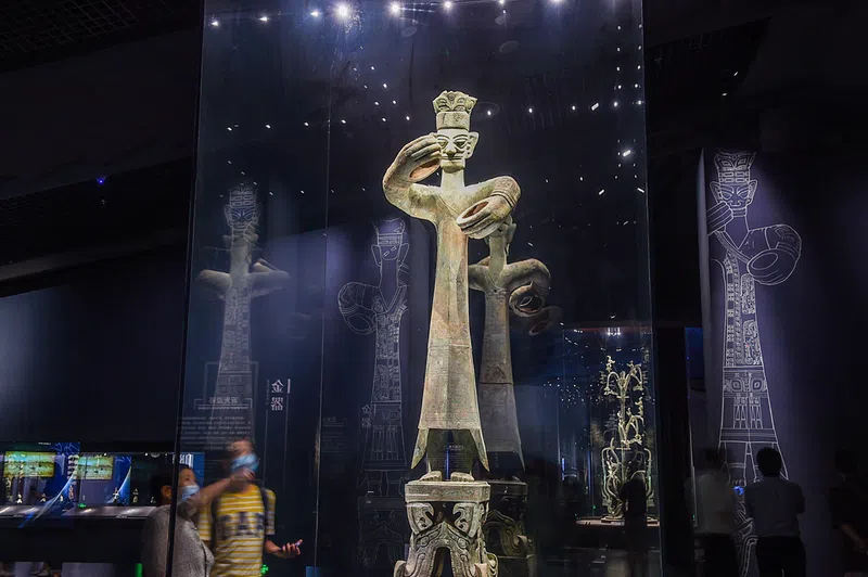 A bronze human statue excavated from Sanxingdui about 2 meters tall with both arms extended as if holding something