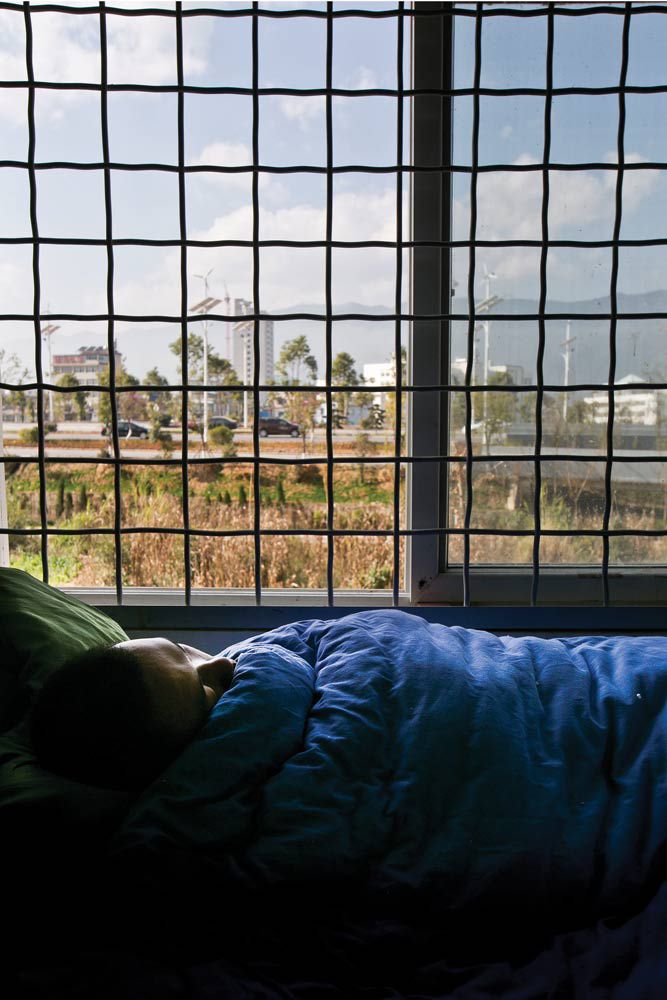 A patient resting at the Third People&#x27;s Hospital in Lincang, Yunnan. Wires are installed in the ward to prevent escape. 