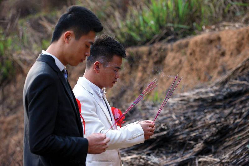 Lu Zhong (right) and Liu Wangqiang became the first gay couple to publicly hold a wedding ceremony in Fujian province in 2012. As part of the ceremony, the couple paid their respects at the grave of Lu&#x27;s late father.