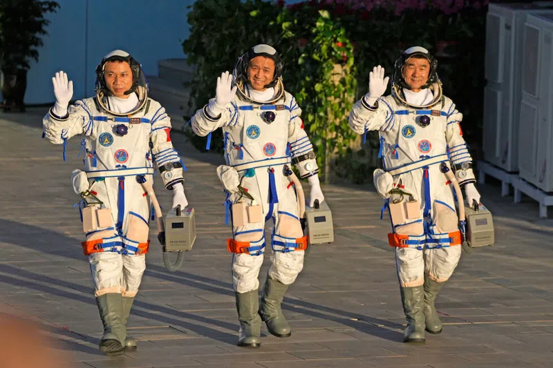 The crew of the Shenzhou-12 (from left to right), Yang Hongbo, Nie Haisheng, and Liu Boming, wave to the crowd as they prepare to board for liftoff at the Jiuquan Satellite Launch Center. (VCG)