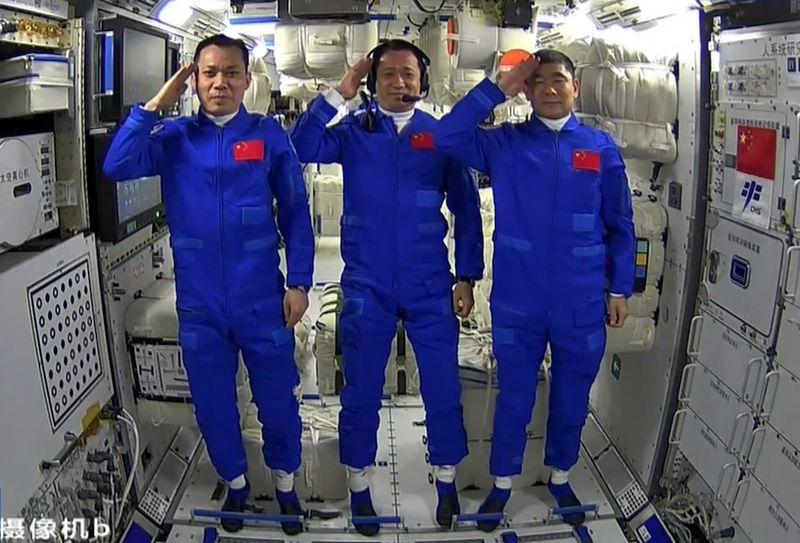 Yang, Nie, and Liu (from left to right) salute to viewers back on Earth after entering the space station