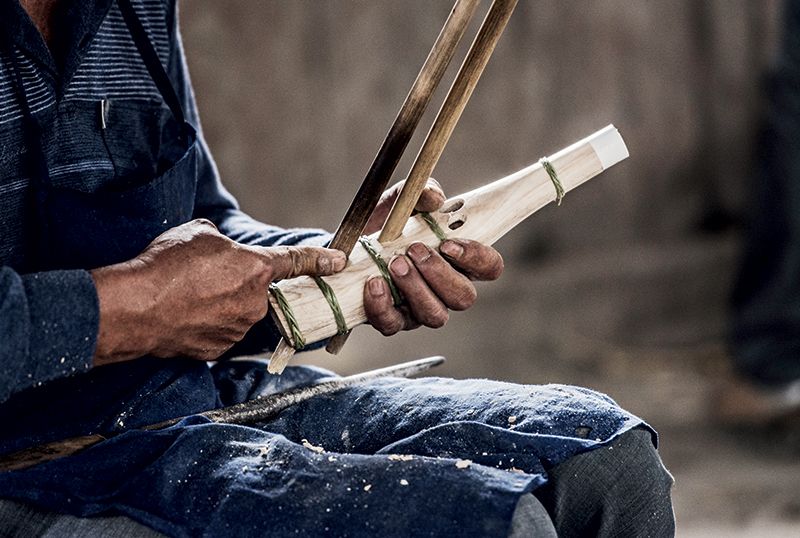 This craftsman molds what will become the body of the instrument