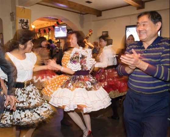 A couple of Beijing ladies give each other a twirl, square dance-style