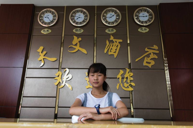 Fifteen-year-old Yuan Tianhui works at the Astro Palace Hotel, where three of the "international" clocks are just for show. Yuan began high school in September, but has never seen the telescope.