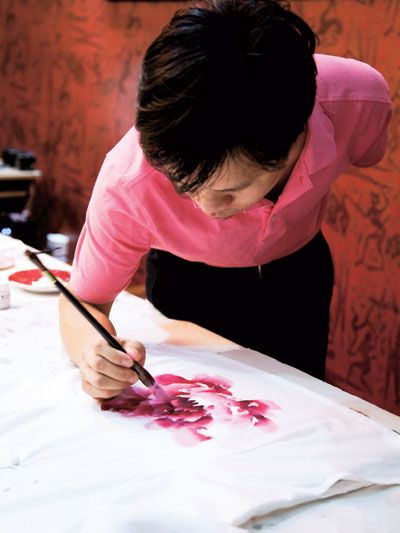 Chang Tao paints a new floral motif for his umbrellas