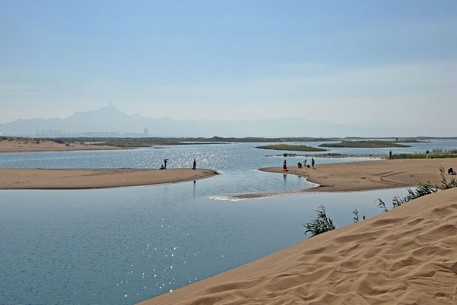 Lake water meets dunes on the western bank, a rare sight anywhere else in China