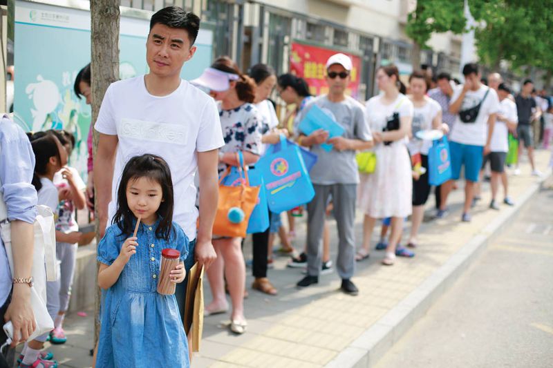 During a blazing hot July day, parents line up for class registration in Beijing